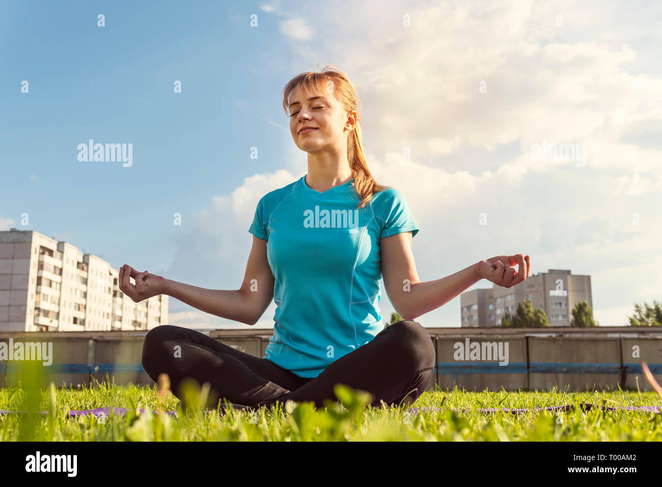 Bionda ragazza atleta a praticare yoga nel parco. Foto Stock