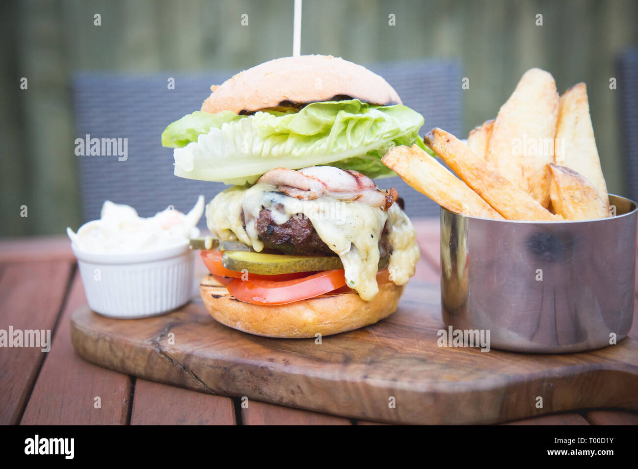 Torre di hamburger di bun servita con patatine e coleslaw Foto Stock