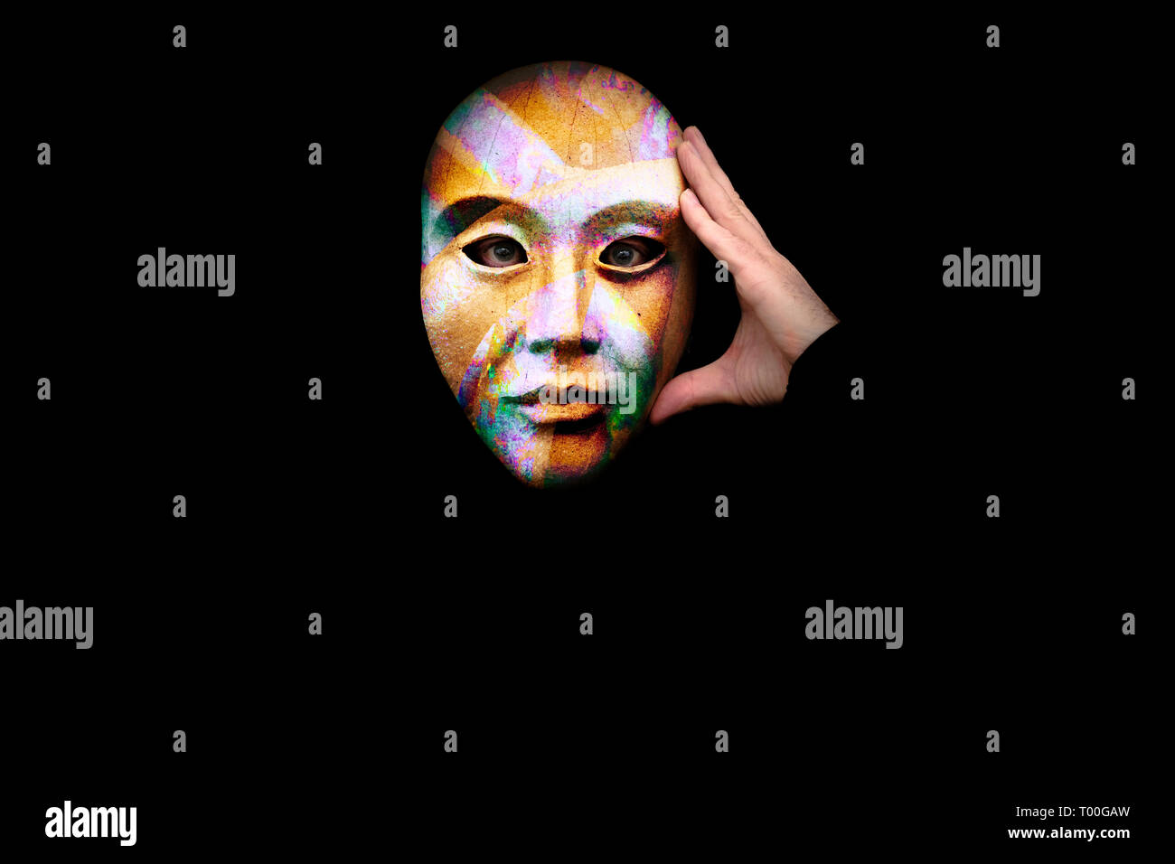 Perplesso persona con la mano per la testa che indossa una maschera colorata contro uno sfondo nero Foto Stock