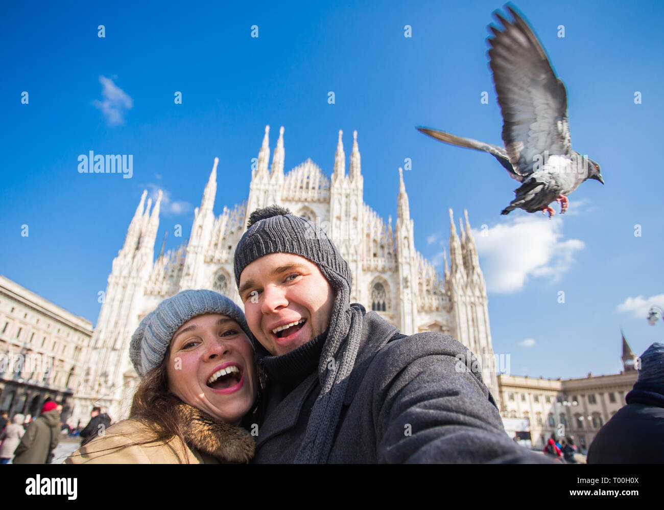 Viaggi, Italia e divertente giovane concetto - Happy turisti prendendo un autoritratto con piccioni nella parte anteriore del Duomo di Milano Foto Stock