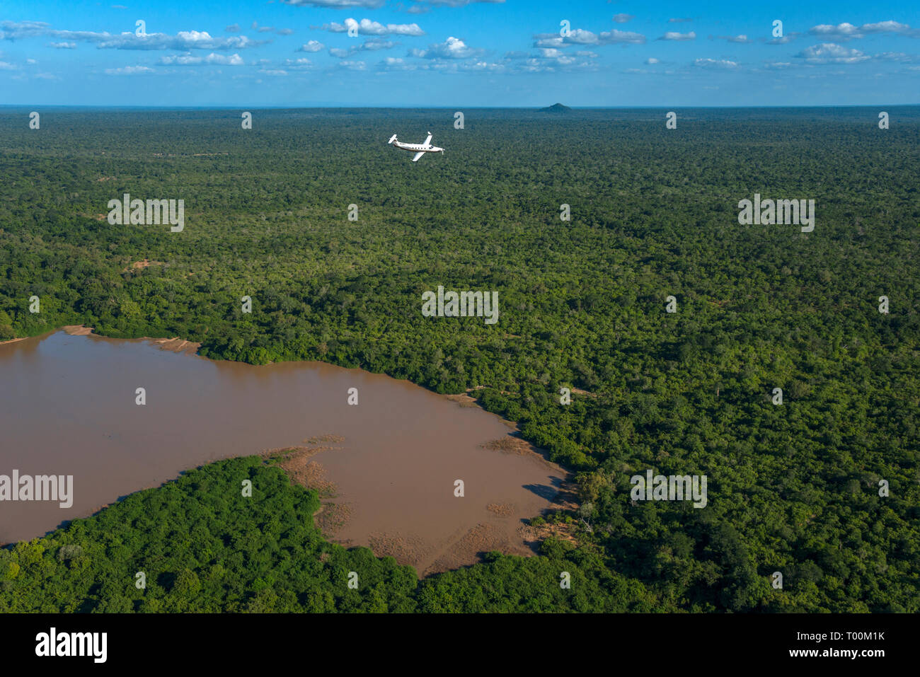 Un Pilatus PC12 aerei sopra un lago della Tanzania. L'accento è sul paesaggio con aeromobili come secondario. Lago Manzie, Foto Stock