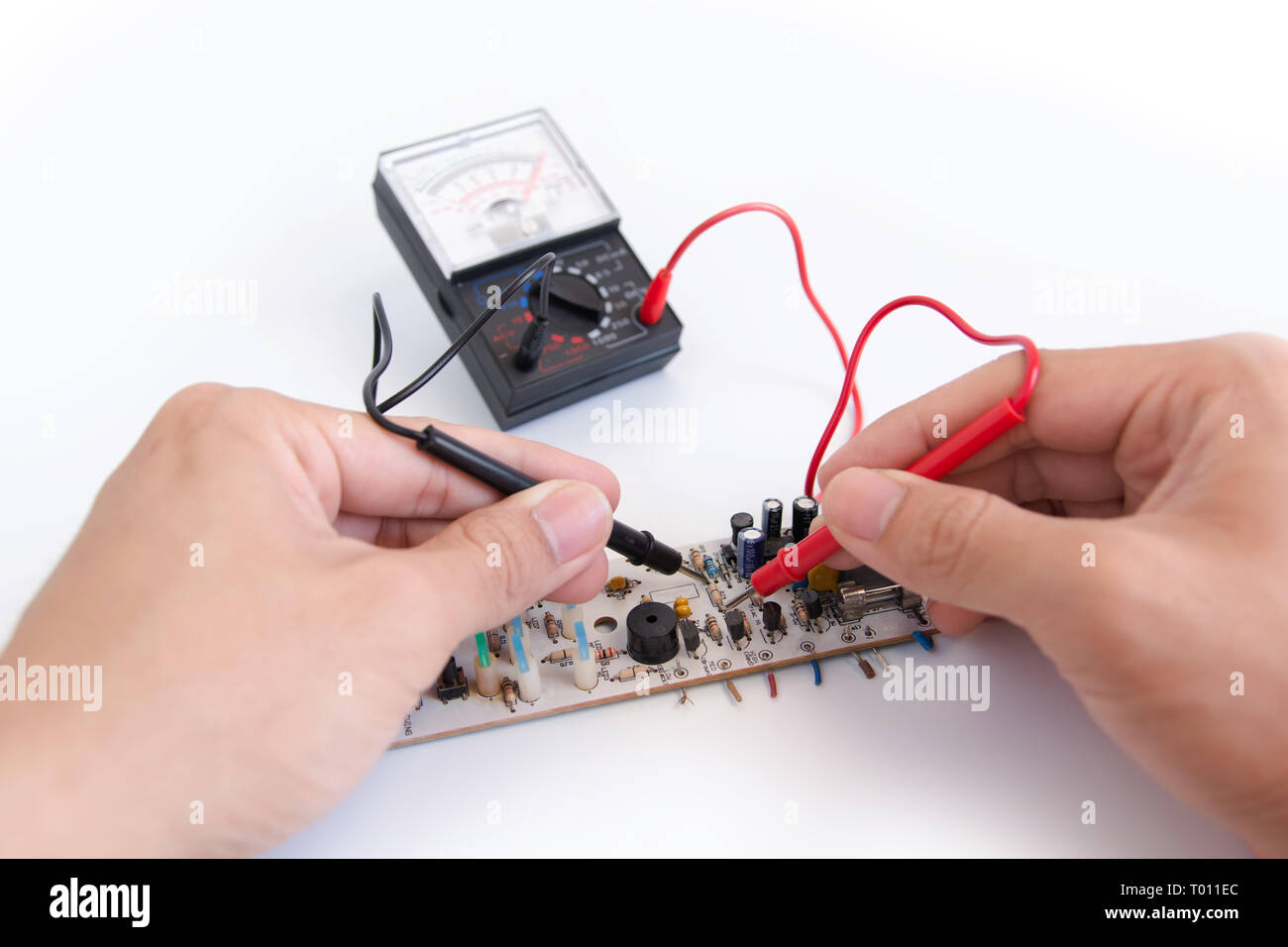 Manuale tecnico con sonde del multimetro riparazione scheda di circuito Foto Stock