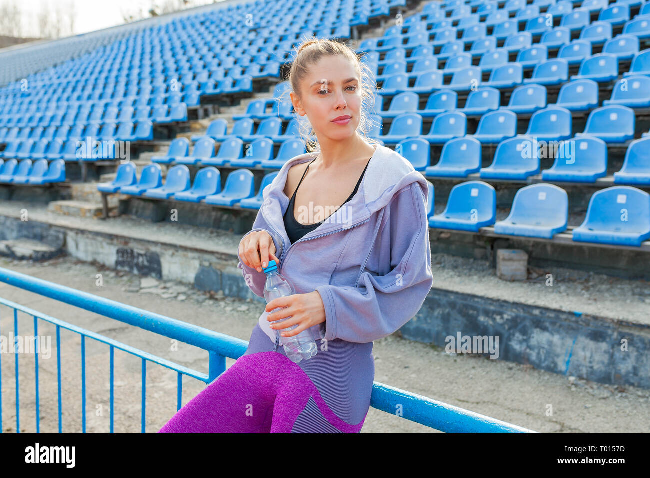 Ritratto di una bella ragazza caucasica atleta su un estate Morning jog. È una donna che indossa un viola felpa con cappuccio. Estate Sport Fitness Healt Foto Stock