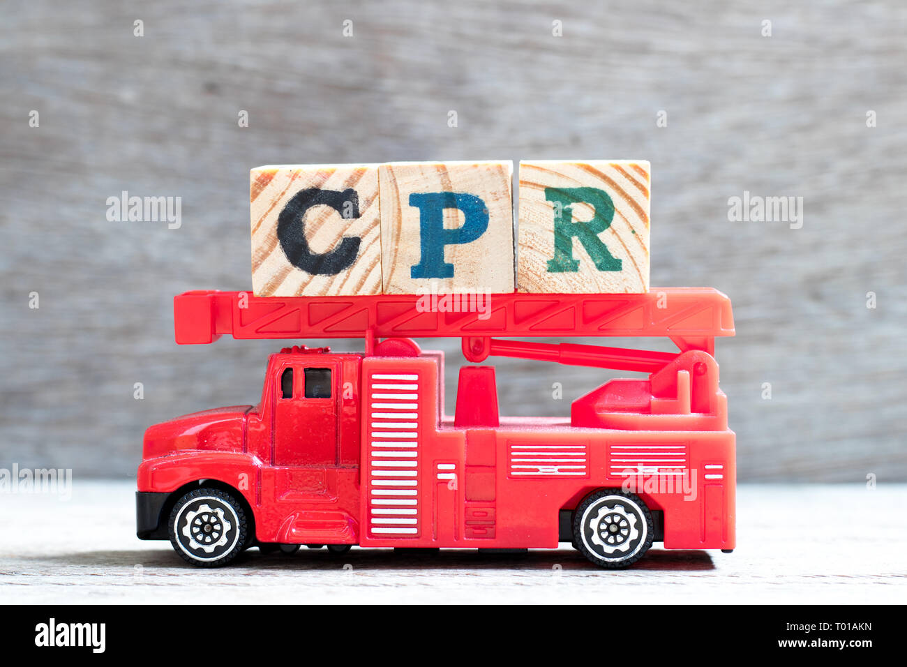 Giocattolo scala antincendio carrello attesa blocco lettera nella parola CPR (abbreviazione di rianimazione cardiopolmonare) su uno sfondo di legno Foto Stock
