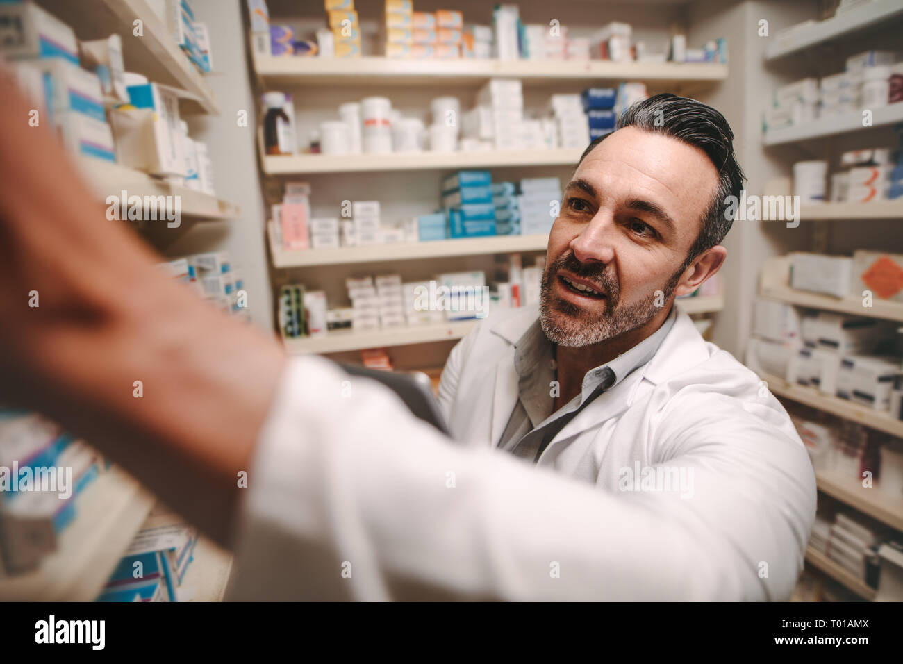 Professionale di farmacista controllo magazzino in un corridoio di una farmacia locale. Farmacia maschio, inventario a pharmacy store. Foto Stock