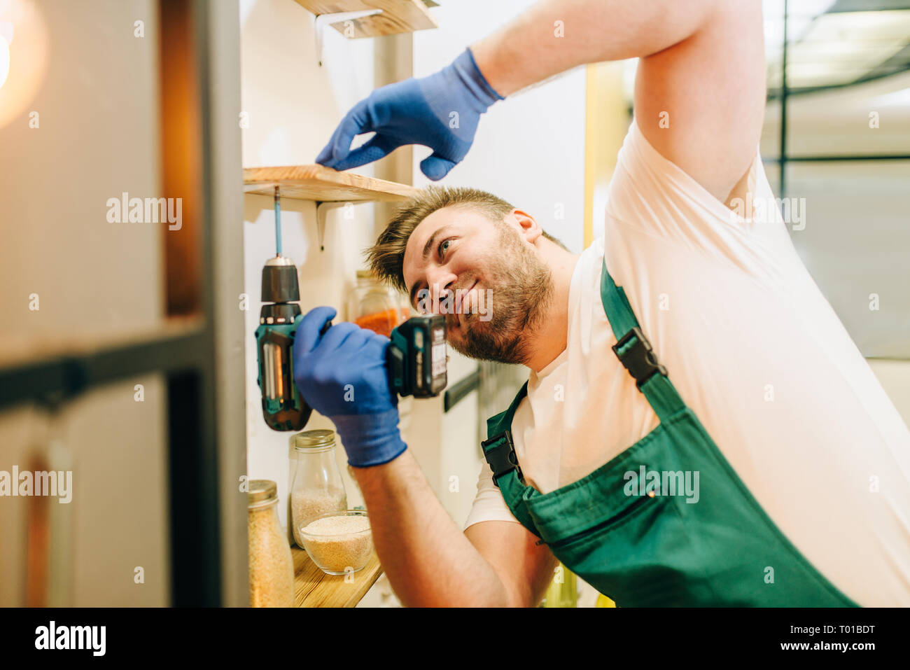 Repairman in uniforme detiene il cacciavite, tuttofare Foto Stock