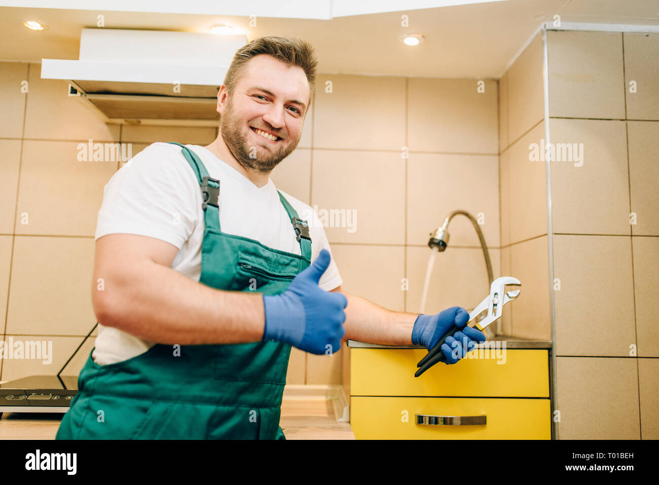 Plumber in uniforme che mostra Thumbs up, tuttofare Foto Stock