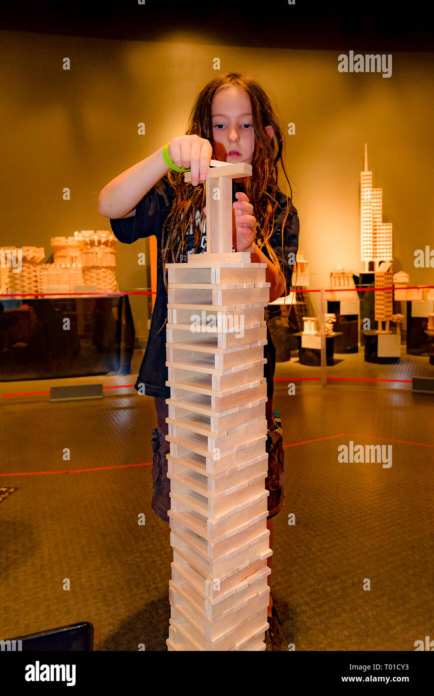 Ragazzo costruisce la torre Keva con tavole di legno al mondo della scienza, Vancouver, British Columbia, Canada (modello rilasciato) Foto Stock
