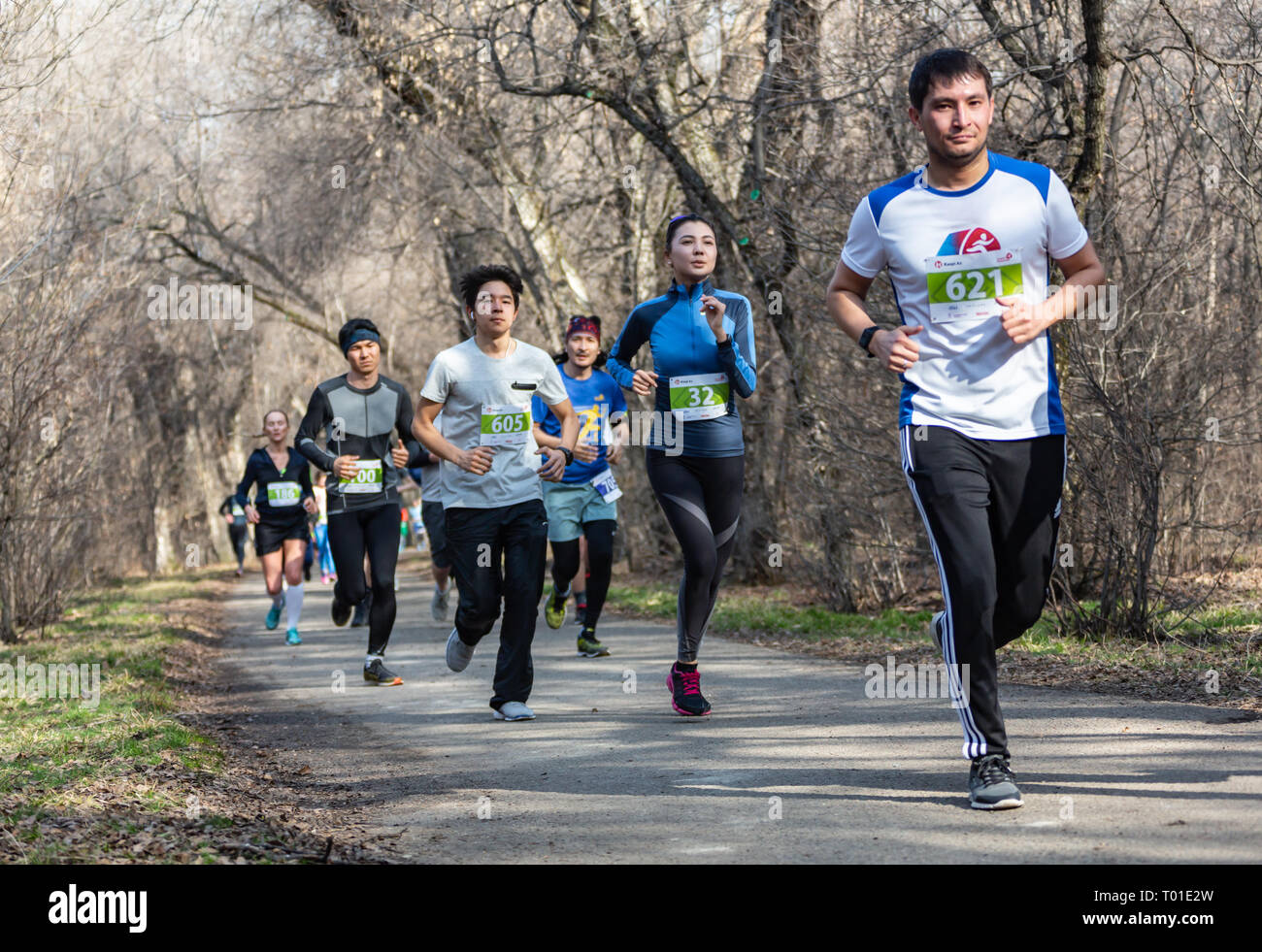 ALMATY KAZAKHSTAN - marzo 16 2019: un folto gruppo di uomini non identificati e le donne viene eseguito attraverso un boschetto durante la Maratona di Primavera nella città di Almaty Foto Stock