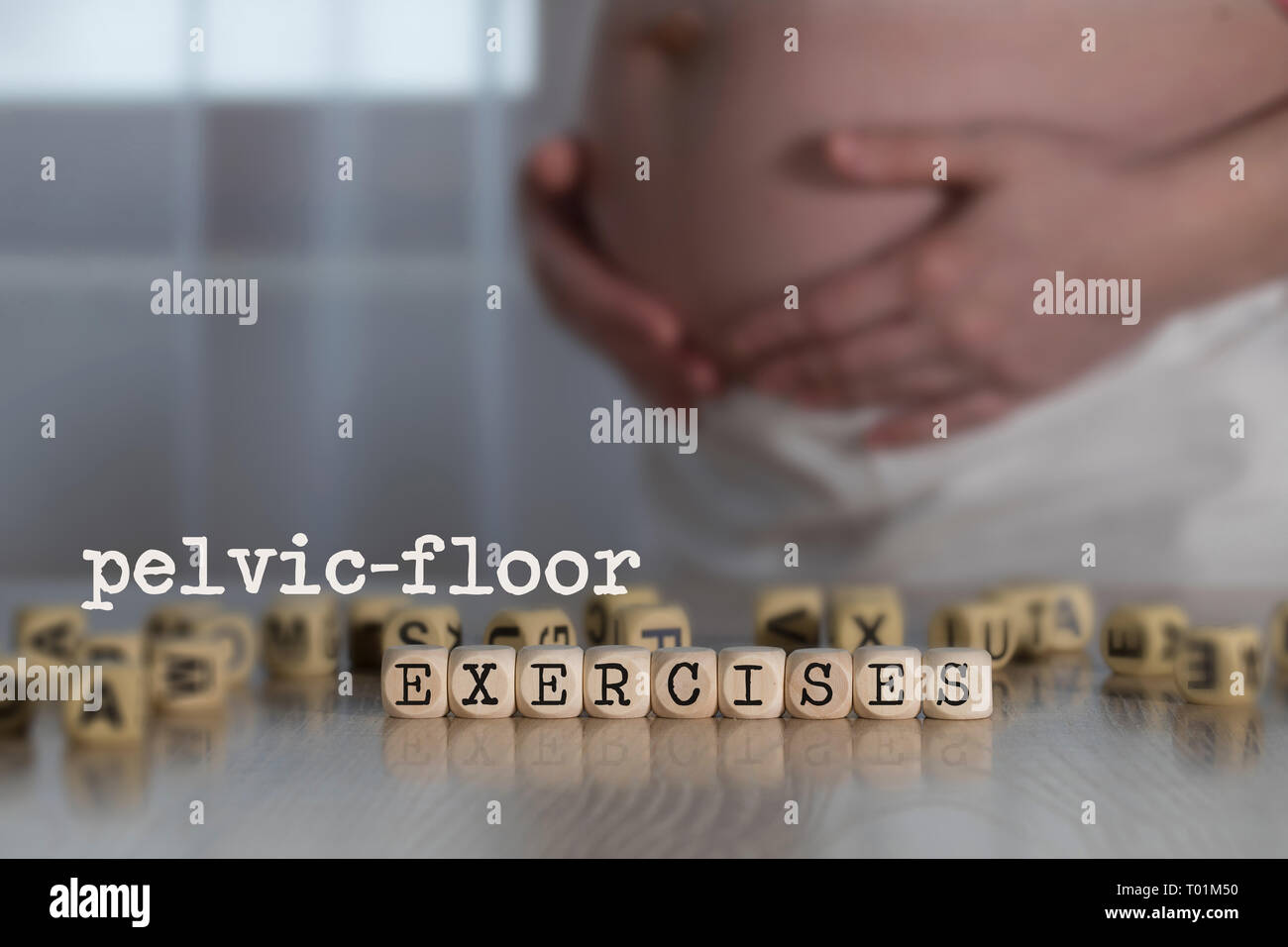 Parole-pelvico esercizi sul pavimento composto da lettere di legno. Donna incinta in background Foto Stock