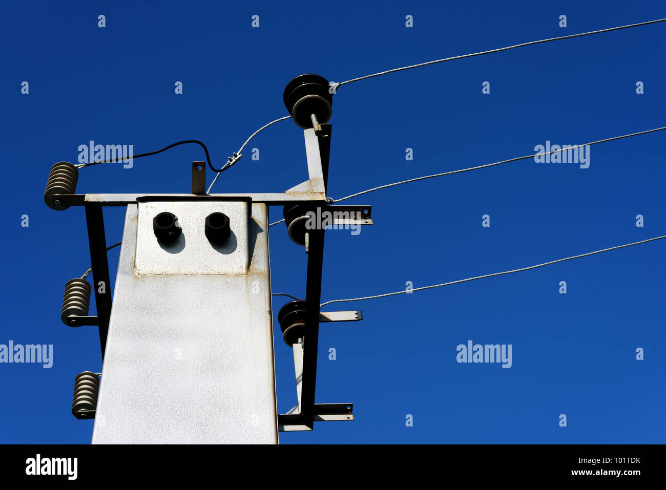 Immagine di una sottostazione elettrica e linee di alimentazione impostato contro un cielo blu all'aperto durante il giorno Foto Stock