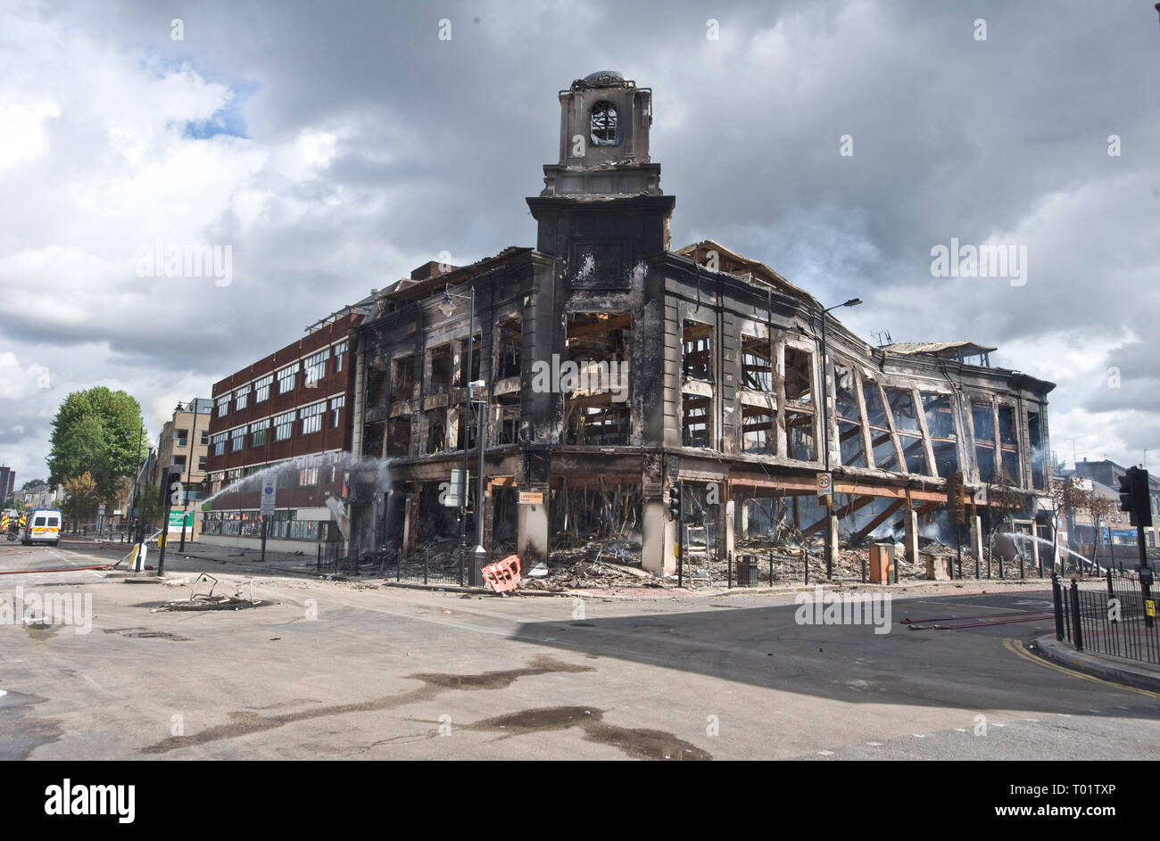 Conseguenze del Tottenham tumulti . I residenti locali indagine i danni compreso un bruciata la polizia van e tappeti negozio di destra distrutta da un incendio doloso . Il negozio edificio risale al 1930 . Local MP David Lammy è raffigurato visitando la scena con i consiglieri locali. Foto Stock