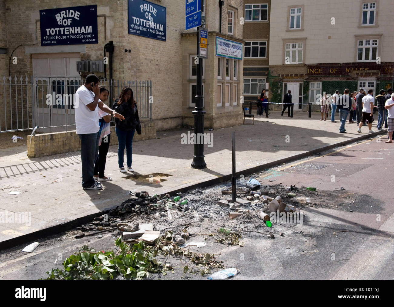 Conseguenze del Tottenham tumulti . I residenti locali indagine i danni compreso un bruciata la polizia van e tappeti negozio di destra distrutta da un incendio doloso . Il negozio edificio risale al 1930 . Local MP David Lammy è raffigurato visitando la scena con i consiglieri locali. Foto Stock