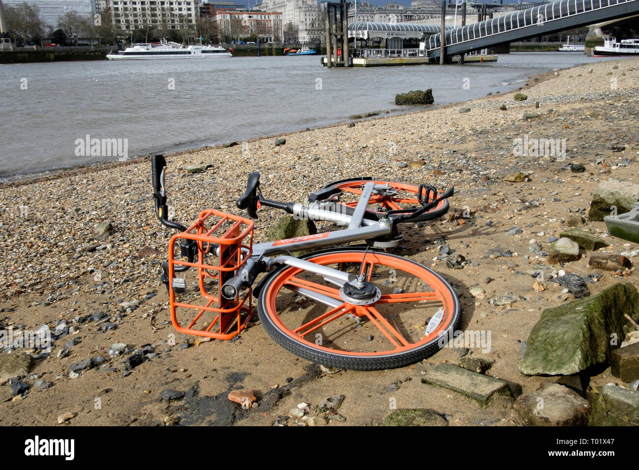 Ciclo di Mobike schema di condivisione bike abbandonati sulla foreshore del fiume Tamigi, Londra. Foto Stock