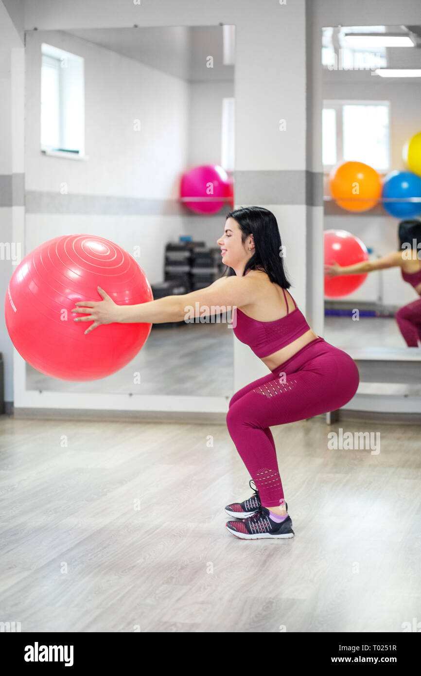 Atletica Giovane ragazza treni in palestra con una fitball. Il concetto di sport, uno stile di vita sano, perdere peso. Foto Stock