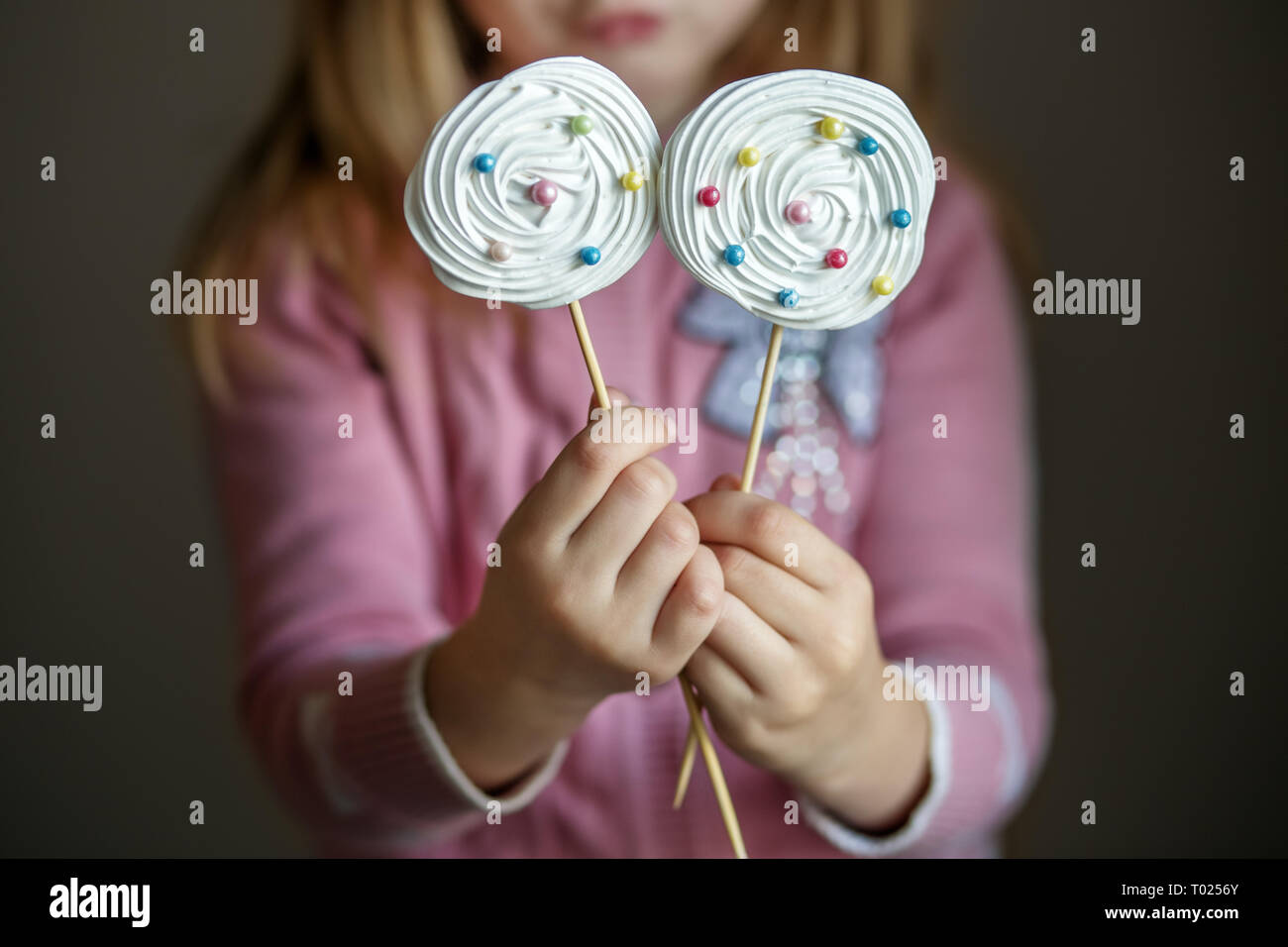 Candy su un bastone in bambini con le mani in mano. Il concetto di caramelle, party, panificio. Foto Stock