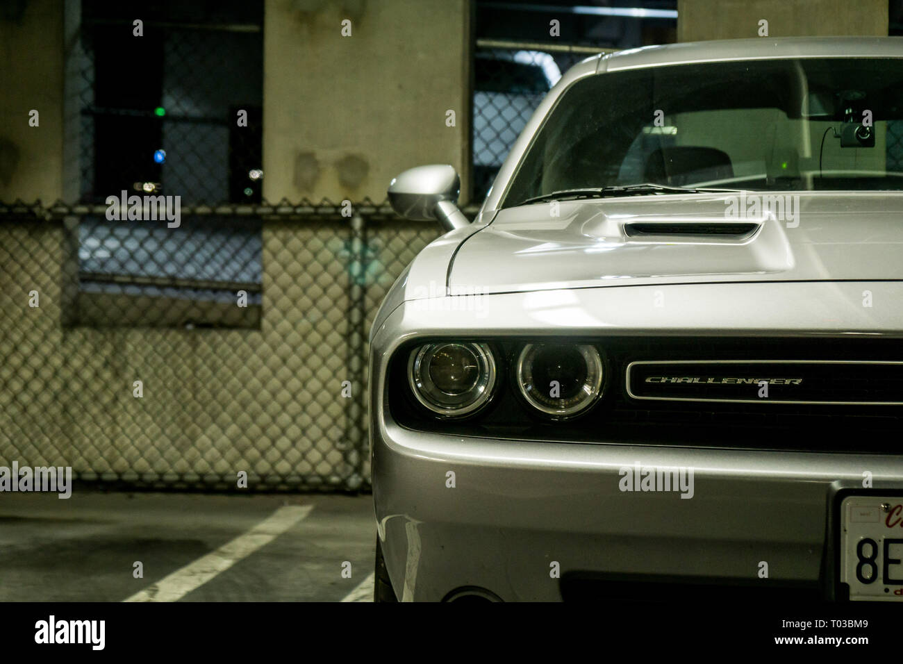 Un primo piano di un moderno American muscle car, la Dodge Challenger, raffigurato in un urbano cercando parcheggio auto Foto Stock