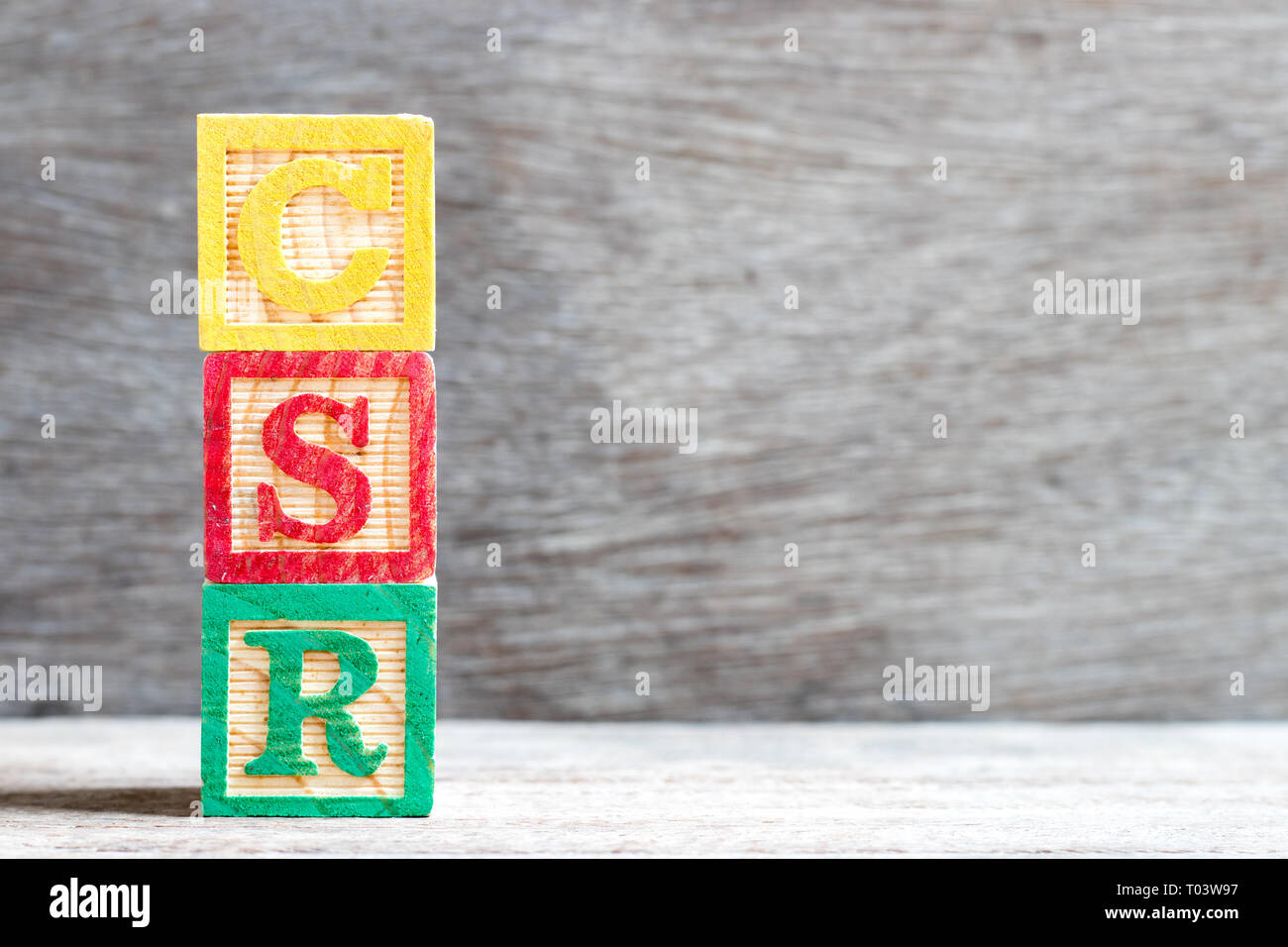 Colore blocco lettera nella parola CSR (abbreviazione di corporate social responsibility) su uno sfondo di legno Foto Stock