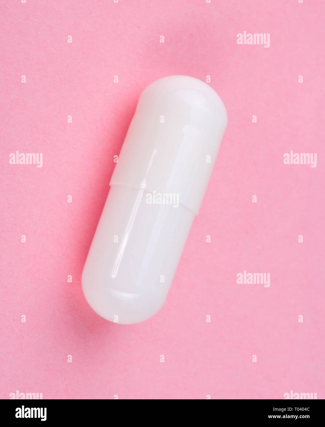 Pillola bianco su sfondo rosa Foto Stock
