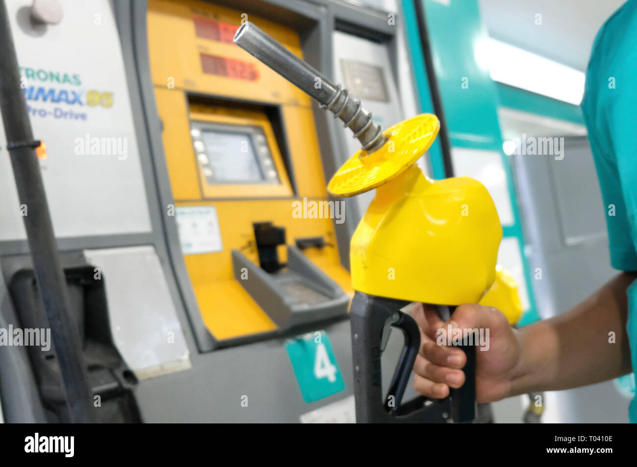 Un uomo visto tenendo l'ugello a benzina a Petronas olio e gas station a Kuala Lumpur. National Petroleum limitata o noto come Petronas è un olio malese e gas company fondata su 17 Agosto 1974 e le sue proprietà dal governo della Malesia. Foto Stock