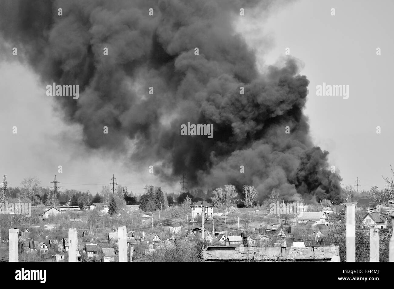 Un mucchio di macerie di cemento con sporgente rebar sullo sfondo di uno spessore di fumo nero nel cielo blu. Sfondo. Il concetto delle conseguenze di Foto Stock