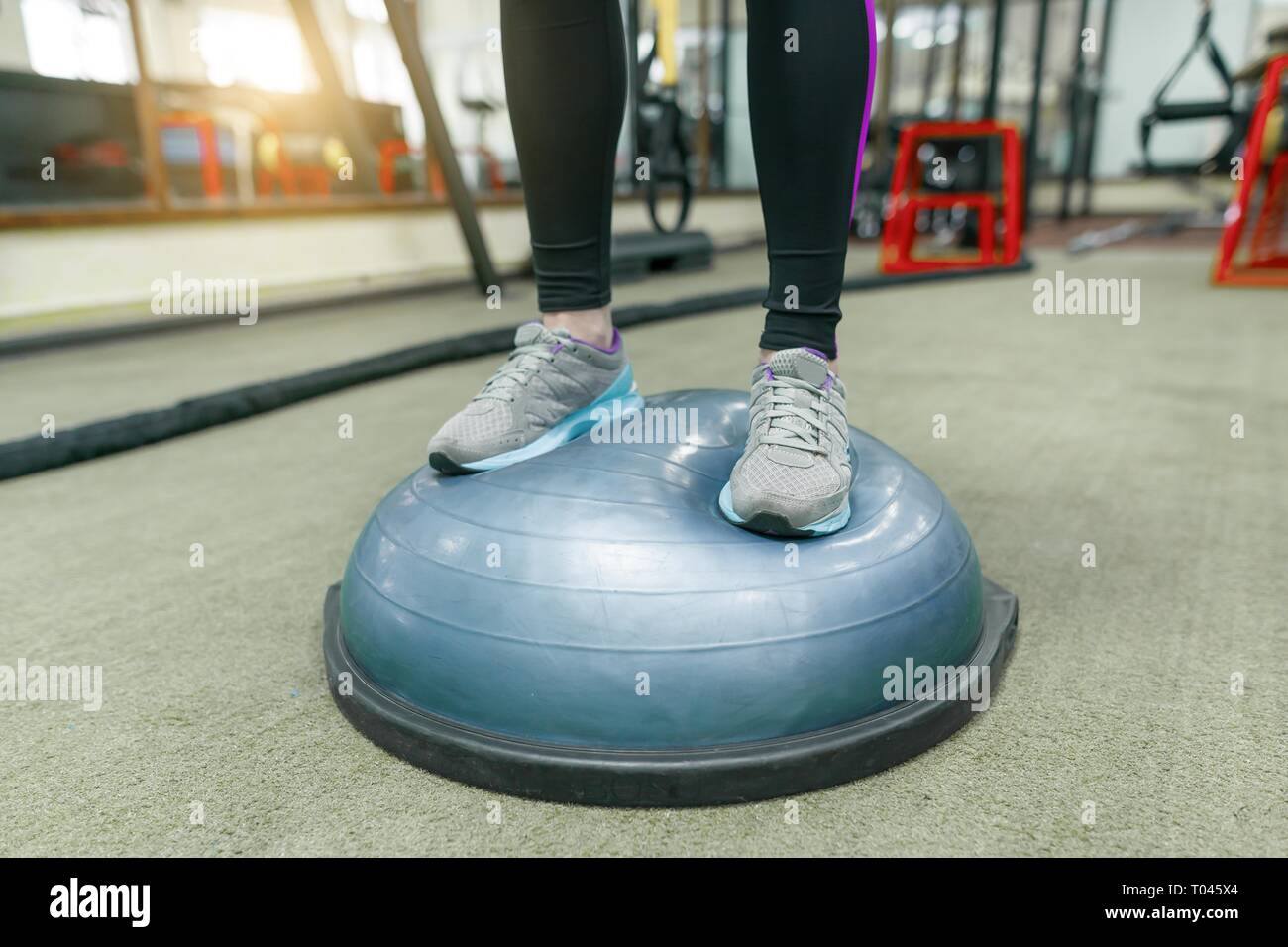 Donna Fitness gambe in sneakers close-up in palestra, femmina facendo esercizi. Fitness, sport, formazione, persone, uno stile di vita sano concetto Foto Stock