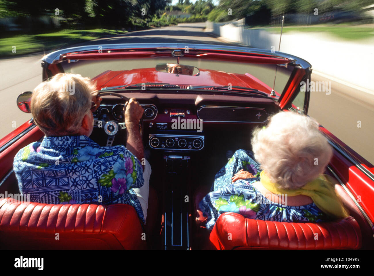 Coppia senior godendo di un giro in un'annata 1966 Mustang Cabrio, STATI UNITI D'AMERICA Foto Stock