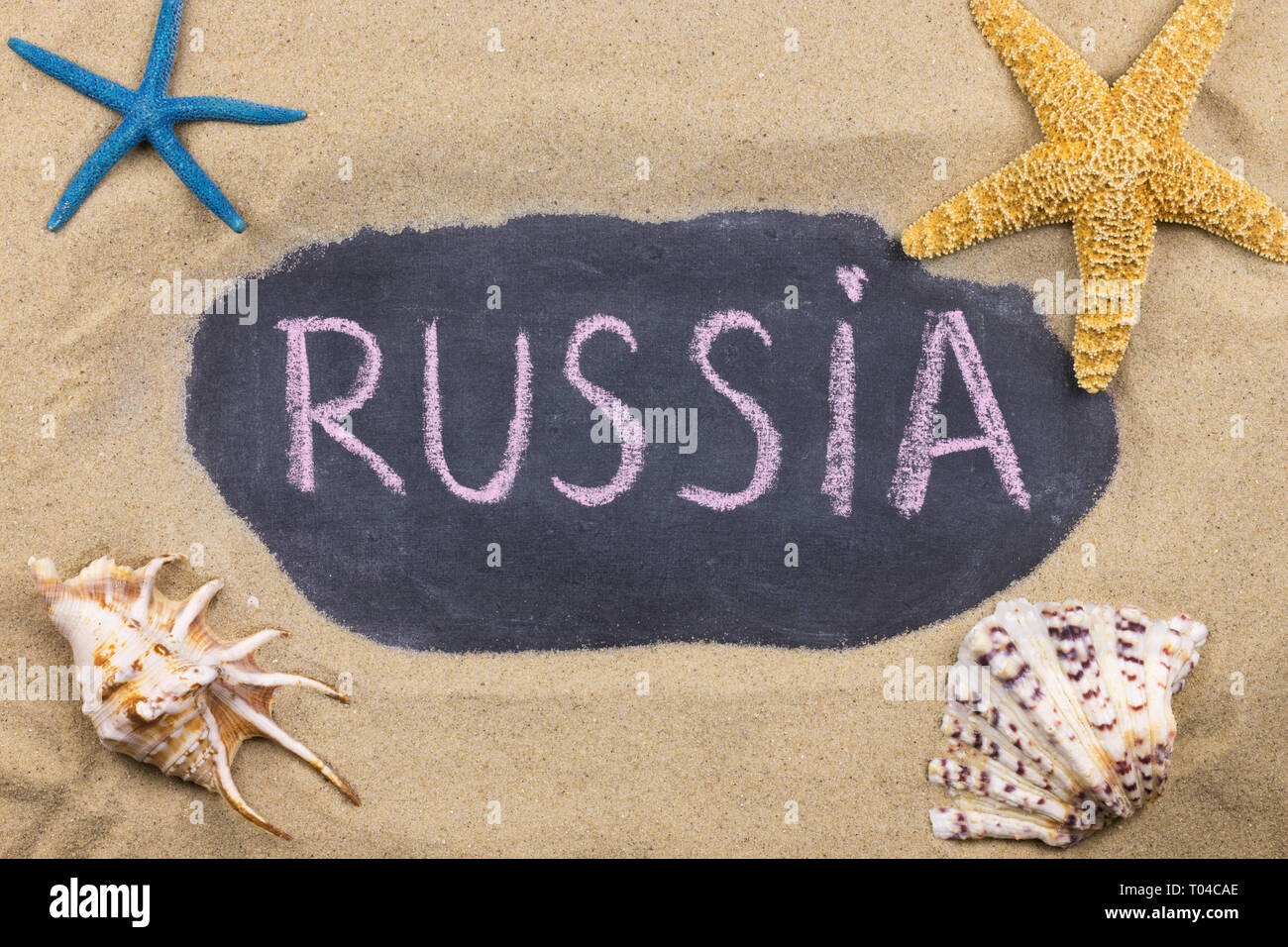 Parola manoscritta RUSSIA scritti in gesso, tra conchiglie e starfishes. Vista superiore Foto Stock