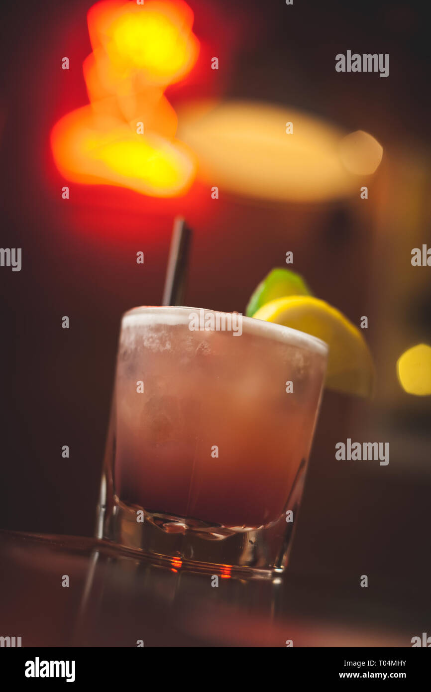 Cocktail rosa con neon sign in background Foto Stock