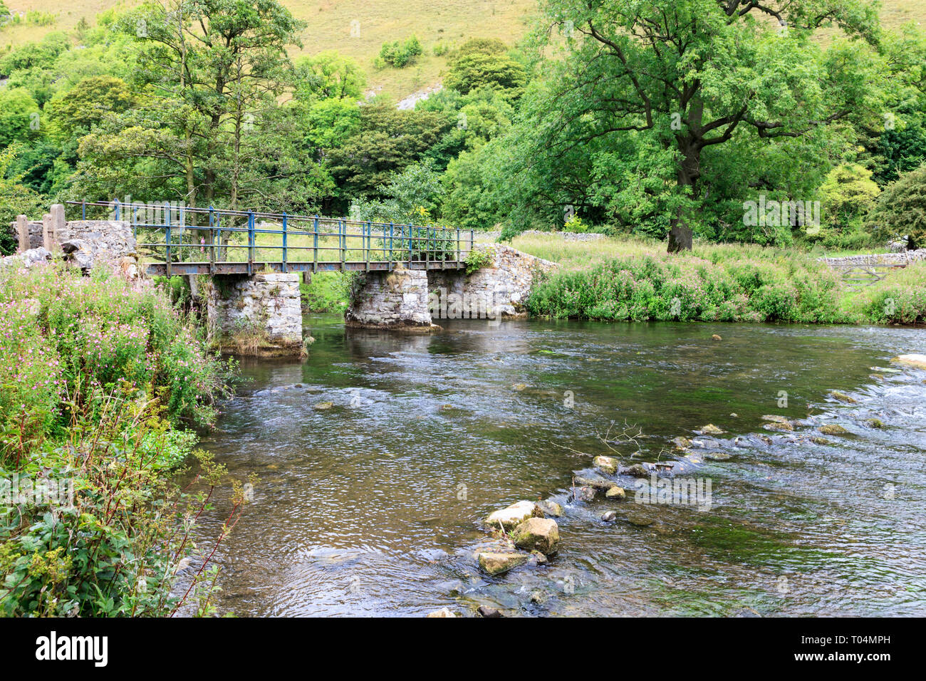 Una passerella sul fiume Wye a Upperdale nel Derbyshire Dales, Peak District, England, Regno Unito Foto Stock