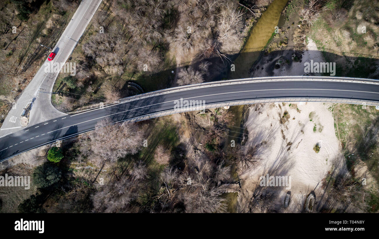 Strada nel verde del prato che la circonda in spagna con auto Foto Stock