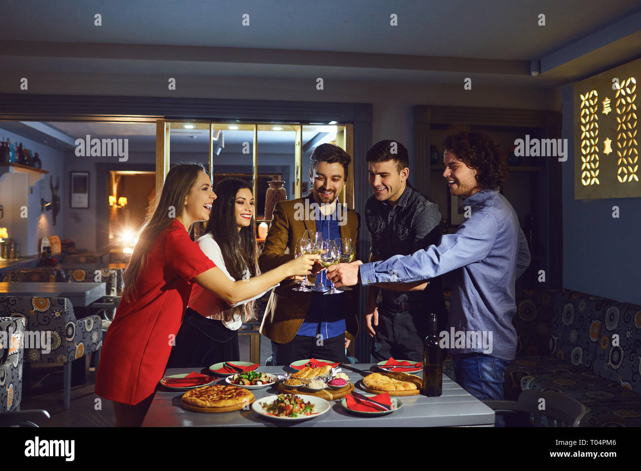 Amici in un ristorante con i bicchieri di vino la sera. Foto Stock