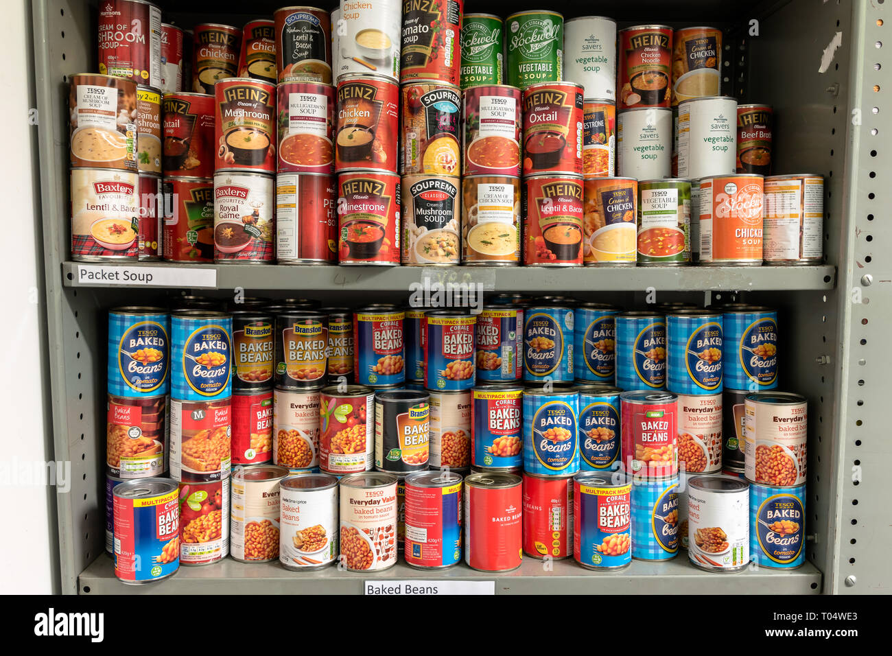 Gli shelf di storage in un Trussell fiducia chiesa locale banca alimentare magazzino nel Regno Unito mostra lattine di fagioli e la minestra pronta per pacchi alimentari Foto Stock
