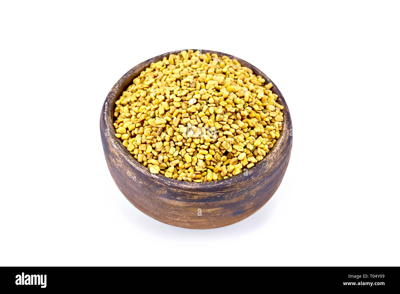 Fieno greco semi in una argilla marrone recipiente isolato su sfondo bianco Foto Stock