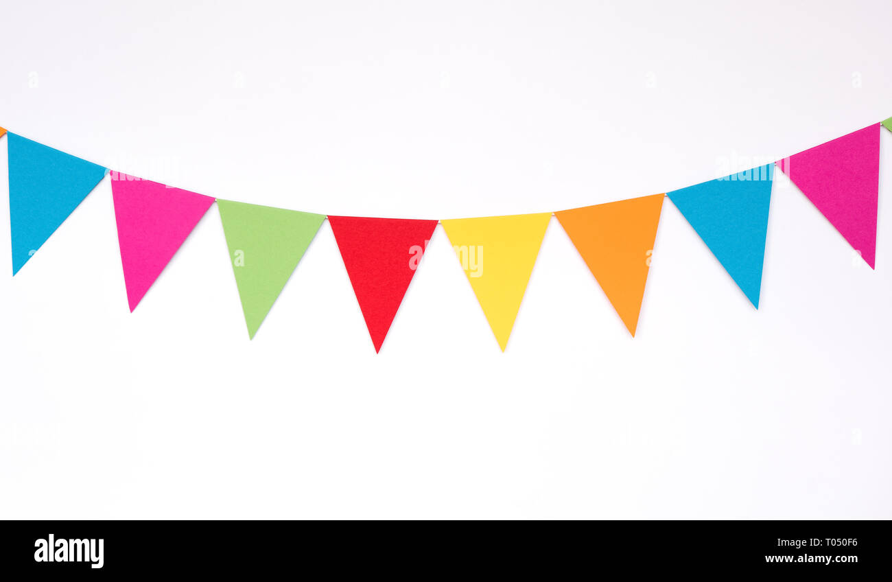 Colorata carta appeso bandiere sul muro bianco sfondo, elementi di arredamento per party, festival, celebrare evento Foto Stock