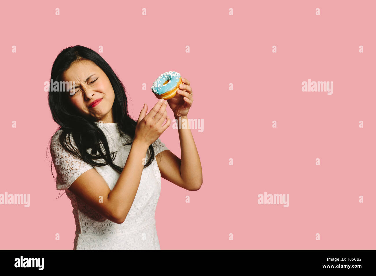 Giovane donna in possesso di una ciambella Foto Stock