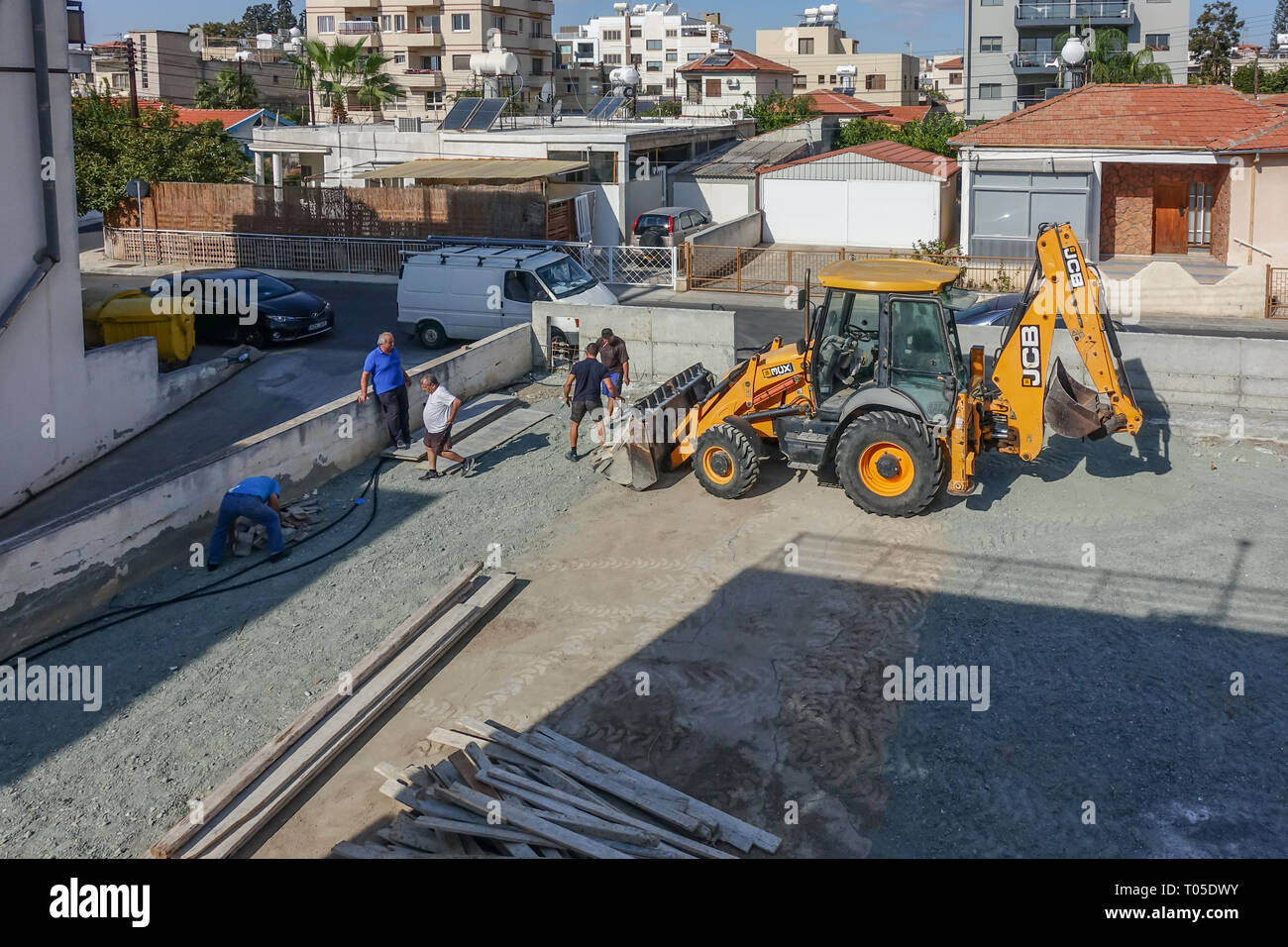Limassol, Cipro - 4 Novembre 2018: JCB con operai sul sito abuilding. Foto Stock