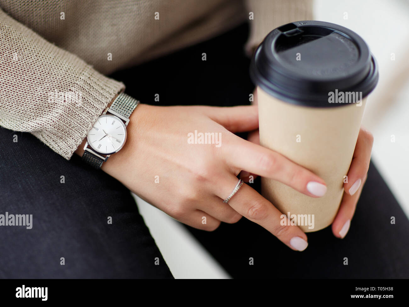 Donna che mantiene un bicchiere di caffè in mani. Foto Stock