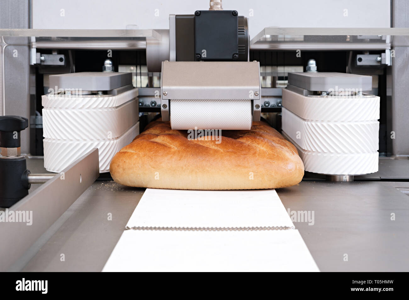 Fette di pane bianco in una macchina da taglio Foto Stock