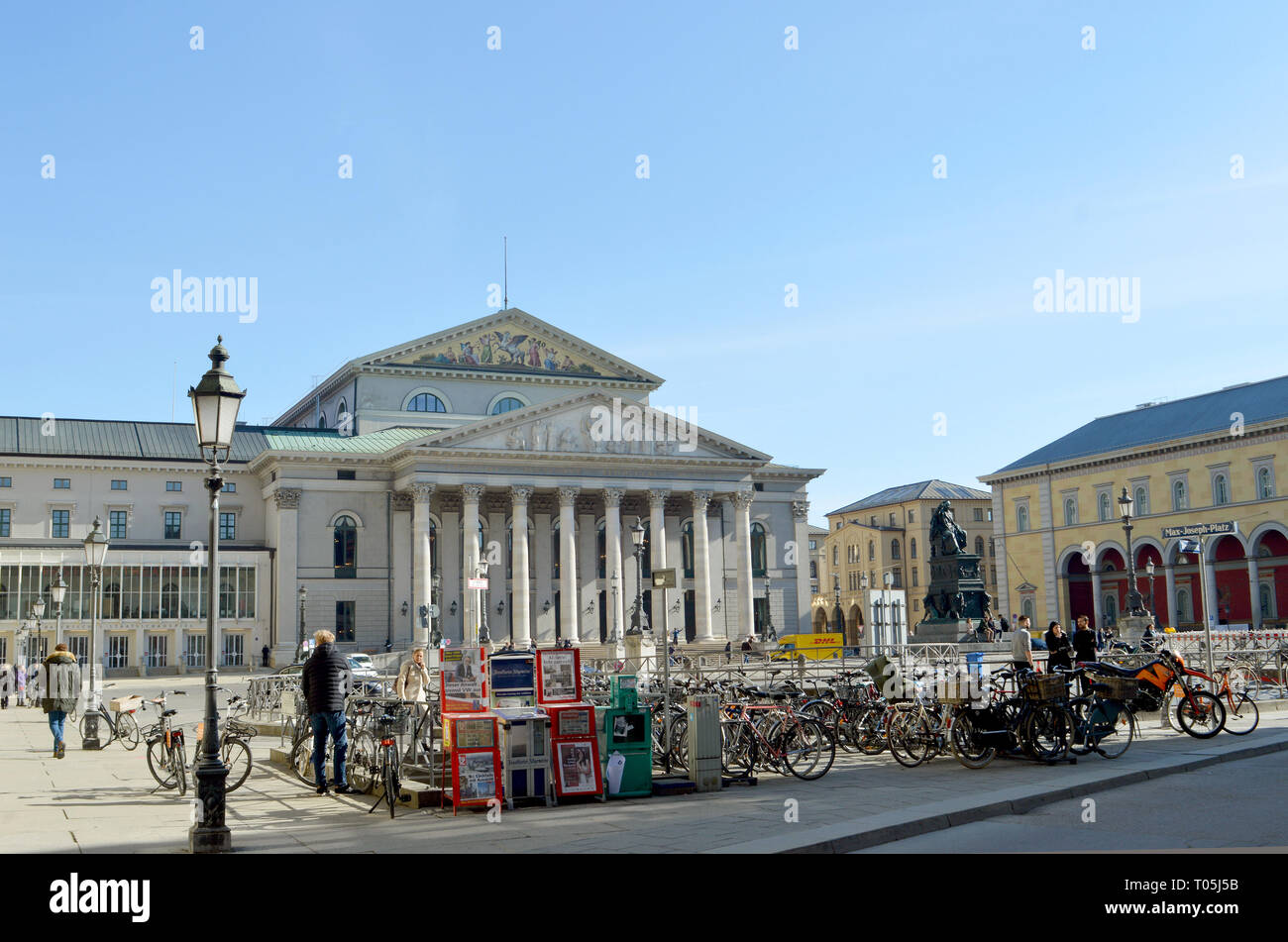 Monaco di Baviera, Germania - 25 febbraio 2019: Biciclette parcheggiate in inverno il sole sulla Max-Joseph-Platz dove una statua di Massimiliano I si erge di fronte al Nat Foto Stock