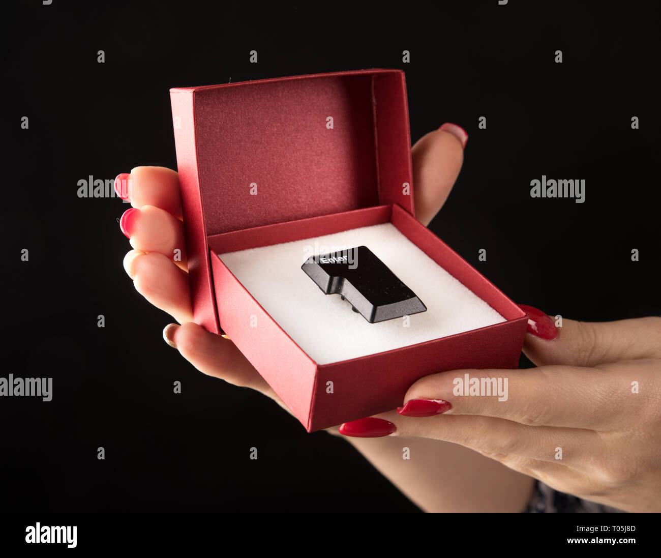 Foto concettuale di un pulsante "Invio" in una confezione regalo rossa Foto Stock