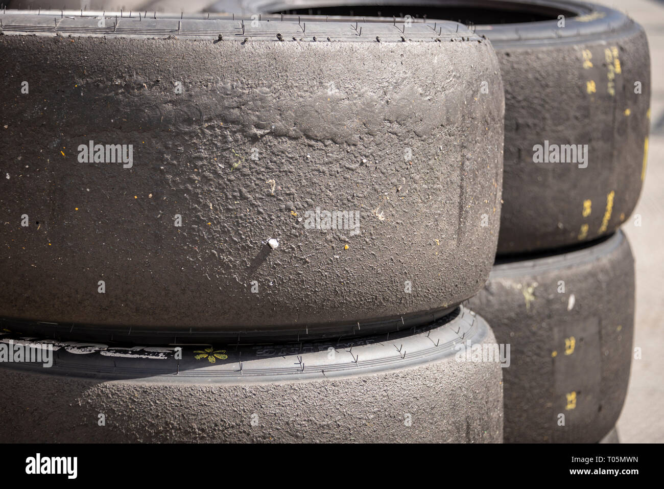 Una pila di motorsport racing pneumatici che mostra i detriti della strada, orizzontale Foto Stock