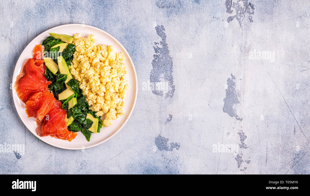 Dieta Ketogenic colazione, uova strapazzate, salmone, avocado, spinaci, vista dall'alto. Foto Stock