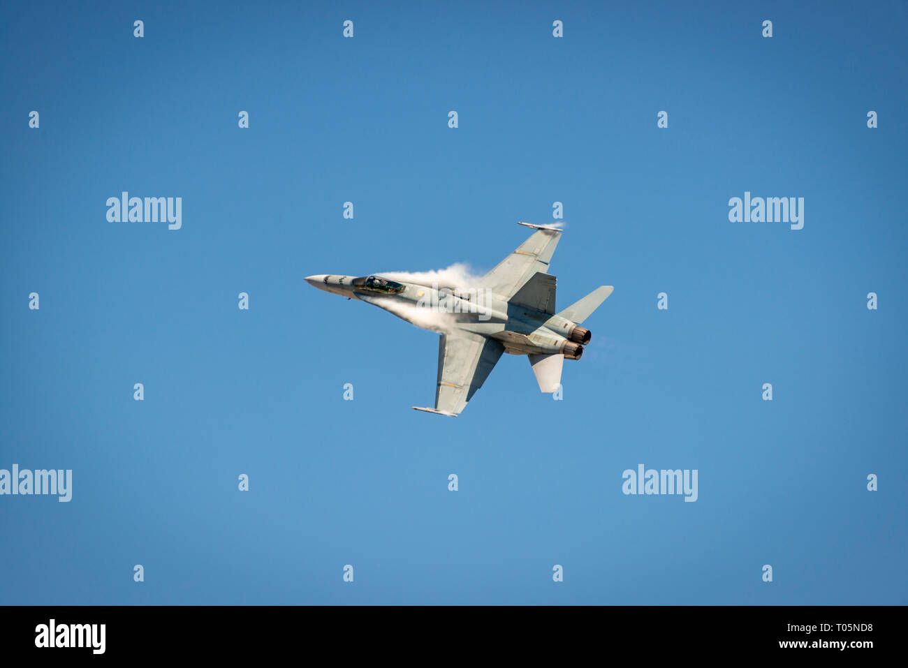 McDonnell Douglas F/A-18 Hornet in volo con contrail intorno alla fusoliera Foto Stock