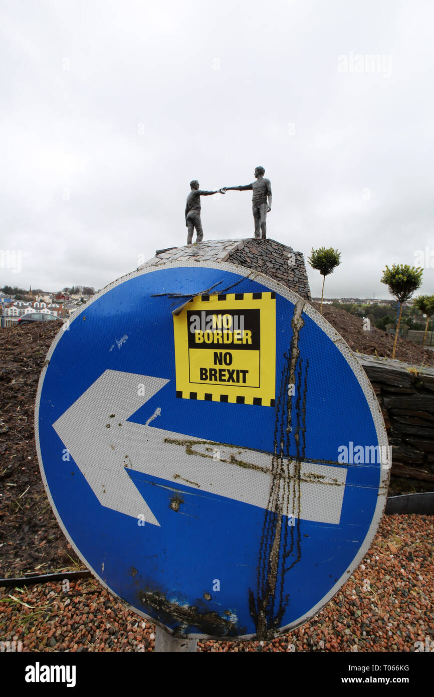 Londonderry, Irlanda del Nord. 16 mar 2019. Un No Brexit segno è visto vicino alla "Mani attraverso la divide " scultura in bronzo di Maurice Harron Derry Londonderry Irlanda del Nord, 16 marzo 2019. - Domenica sanguinante, talvolta chiamato il massacro Bogside, è stato un incidente il 30 gennaio 1972 nell'area Bogside di Derry, Irlanda del Nord, quando i soldati britannici shot 28 civili disarmati durante una marcia di protesta contro l'internamento. Quattordici persone sono morte: tredici sono stati uccisi a titolo definitivo, mentre la morte di un altro uomo quattro mesi più successivamente è stato attribuito alle sue ferite. Credito: Irish occhio/Alamy Live News Foto Stock