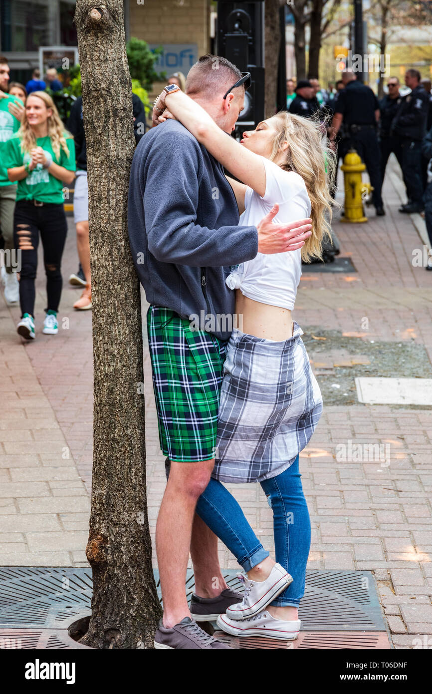 CHARLOTTE, NC, Stati Uniti d'America-3/16/19: una giovane coppia abbraccia. L uomo indossa un kilt, e la donna un plaid kilt over jeans. Foto Stock