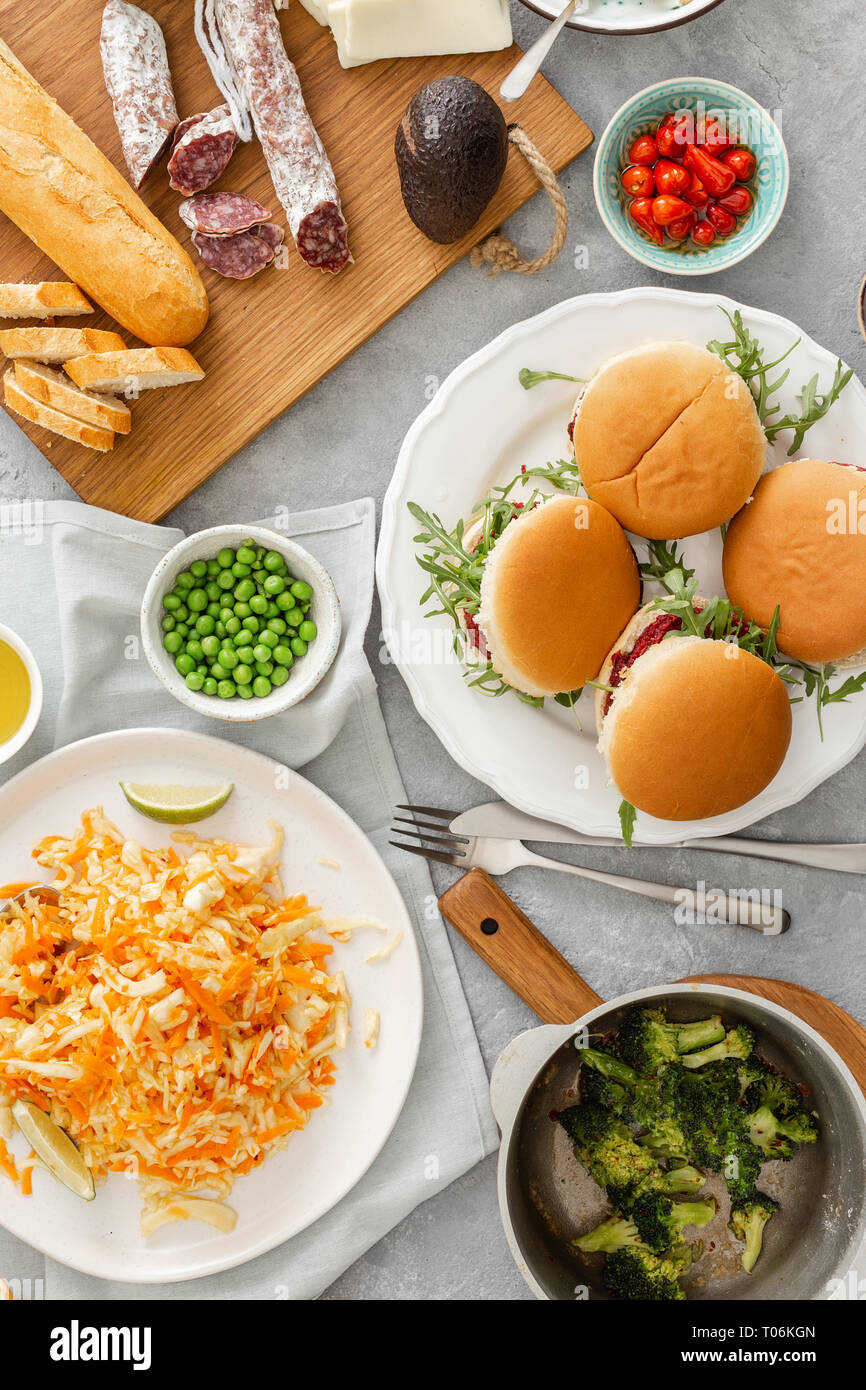 Angolo di Alta Vista del Summer Party food concept. Hamburger Vegetariano con cibi diversi. Cibo vegetariano non è solo. Varie il cibo sulla tavola laici piatta Foto Stock