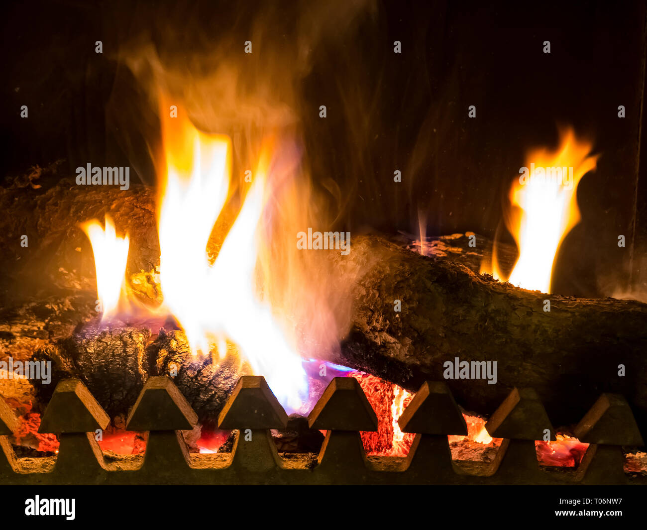 Bruciano carboni e alimentarsi in forno con fiamma arancione Foto Stock