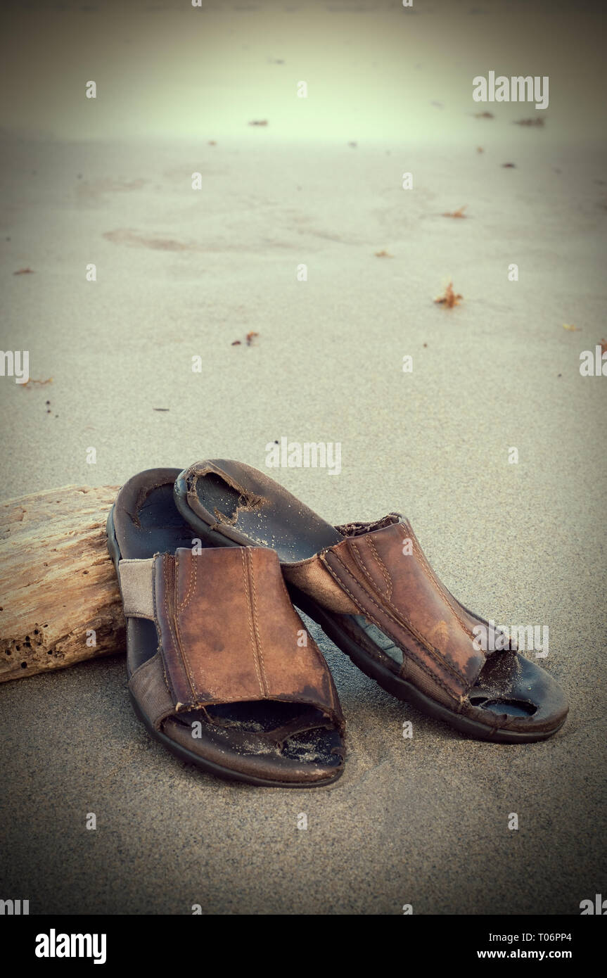 Color seppia vecchi sandali di cuoio su una spiaggia tropicale Foto stock -  Alamy