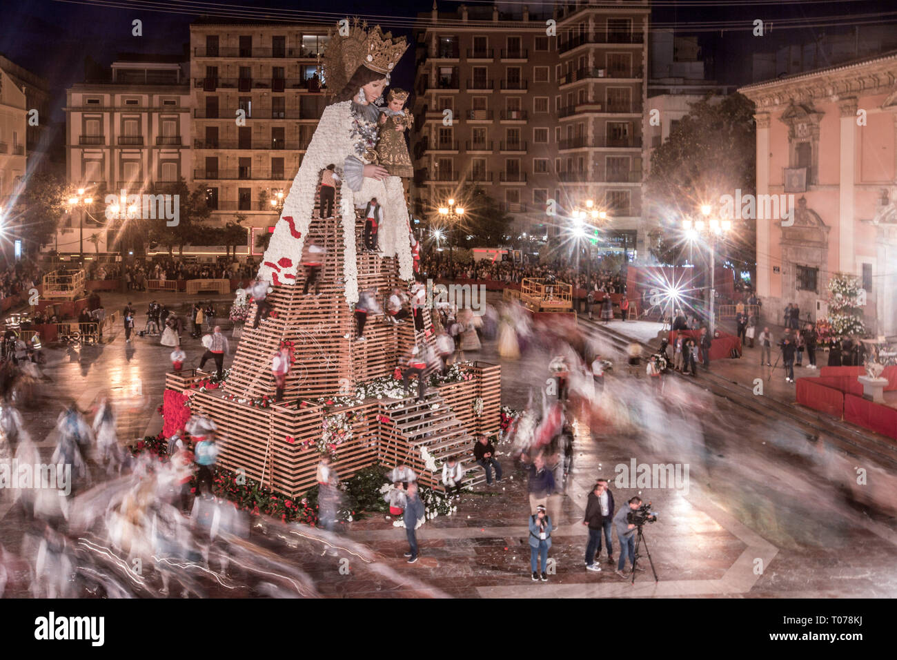 Omaggio floreale per la Virgen de los Desamparados (Madonna del Forsaken). Da tutte le parti della città i gruppi convergono sulla Plaza de la Virgen, accompagnato da gruppi musicali e portante i grappoli di fiori per essere collocato ai piedi della figura della Vergine nel corso del festival Las Fallas. Fallas sono enormi sculture raffiguranti personaggi famosi o gli eventi attuali per le strade di Valencia che si vede durante il 'Las Fallas Festival", le sculture saranno poi masterizzare su Marzo 19, 2019 come un omaggio a San Giuseppe, patrono dei falegnami' Guild. Foto Stock